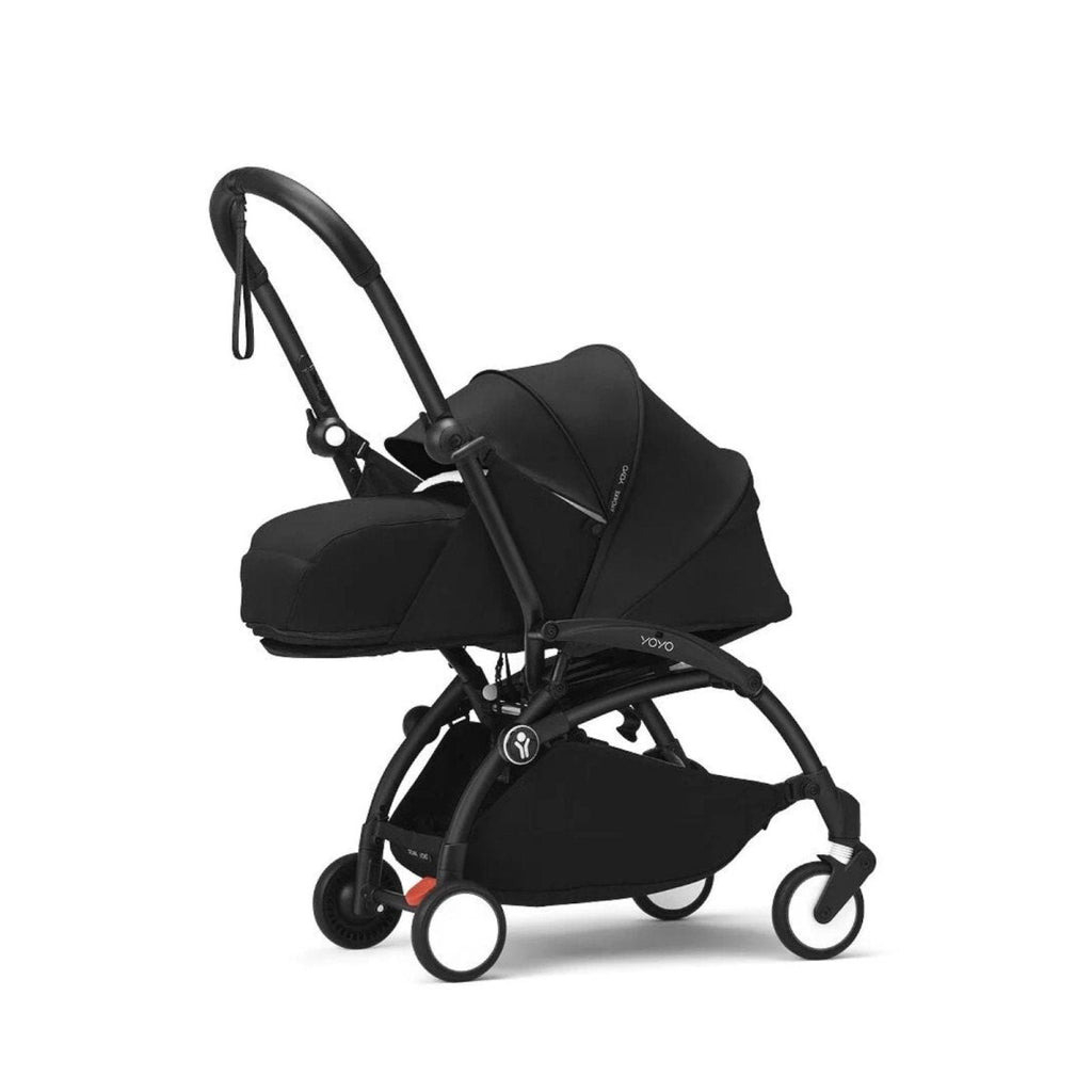 Black stroller with canopy, padded support, and five-point harness