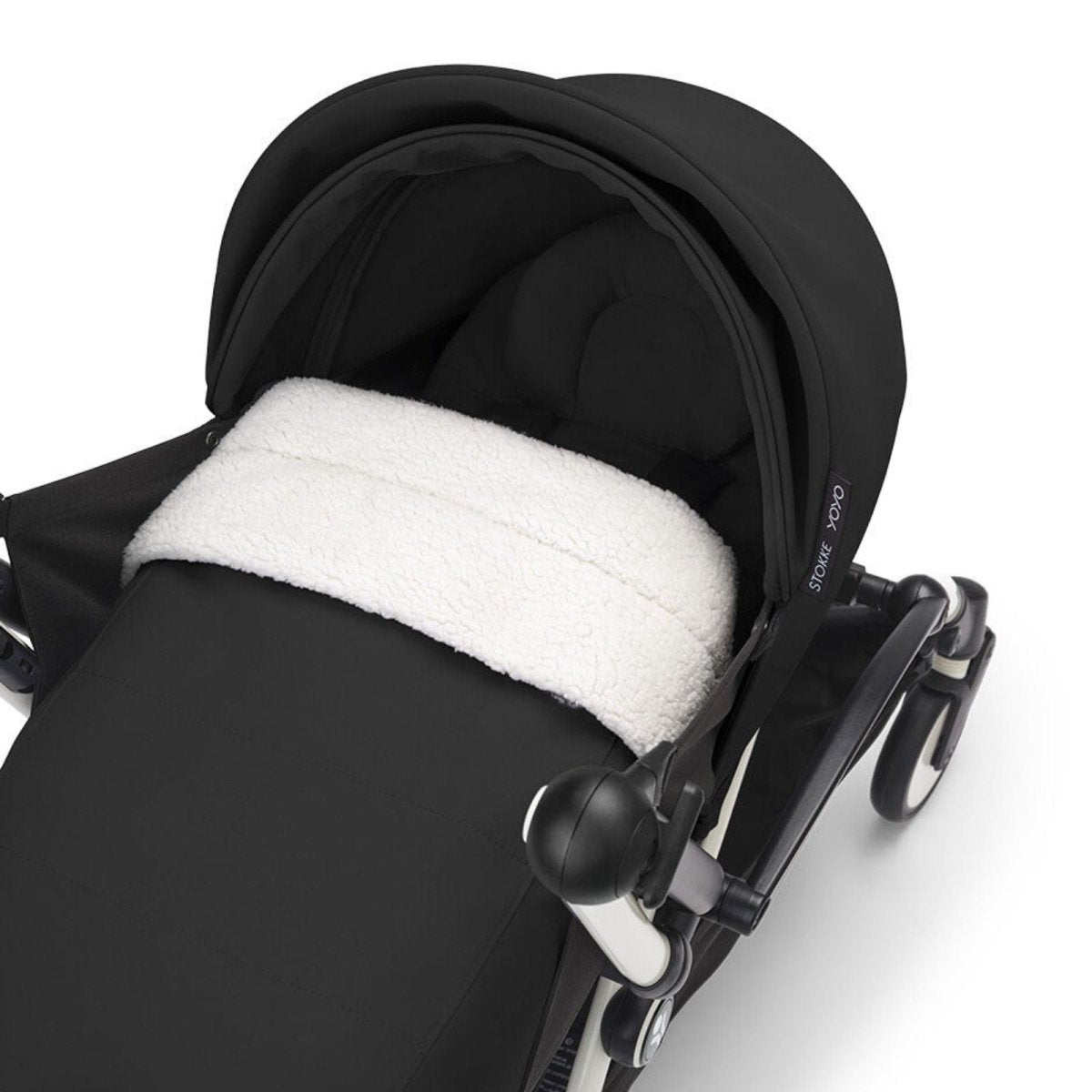 Black stroller seat with dark canopy and white fleece newborn insert
