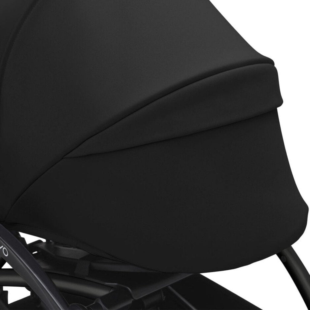 Black stroller legrest and side panel upholstery with curved stitching