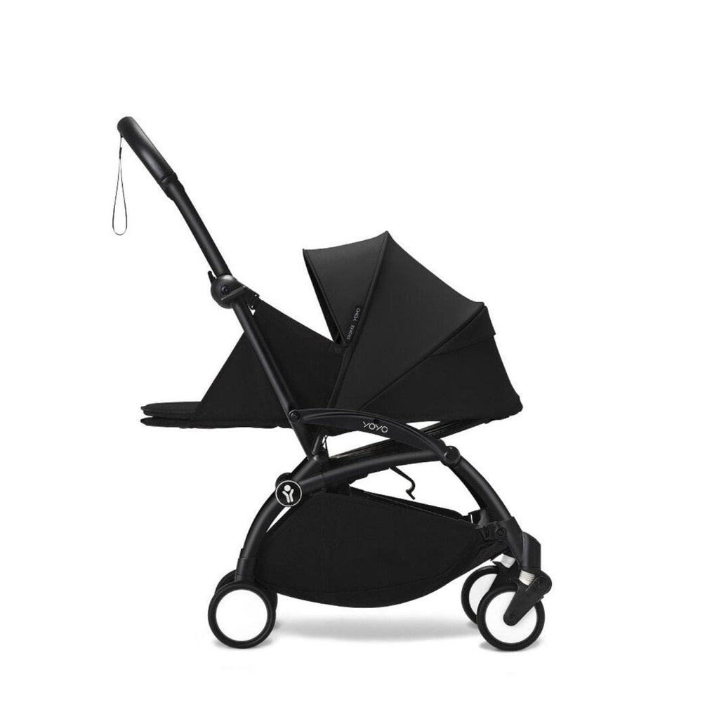 Black stroller with canopy and padded newborn cover in side view