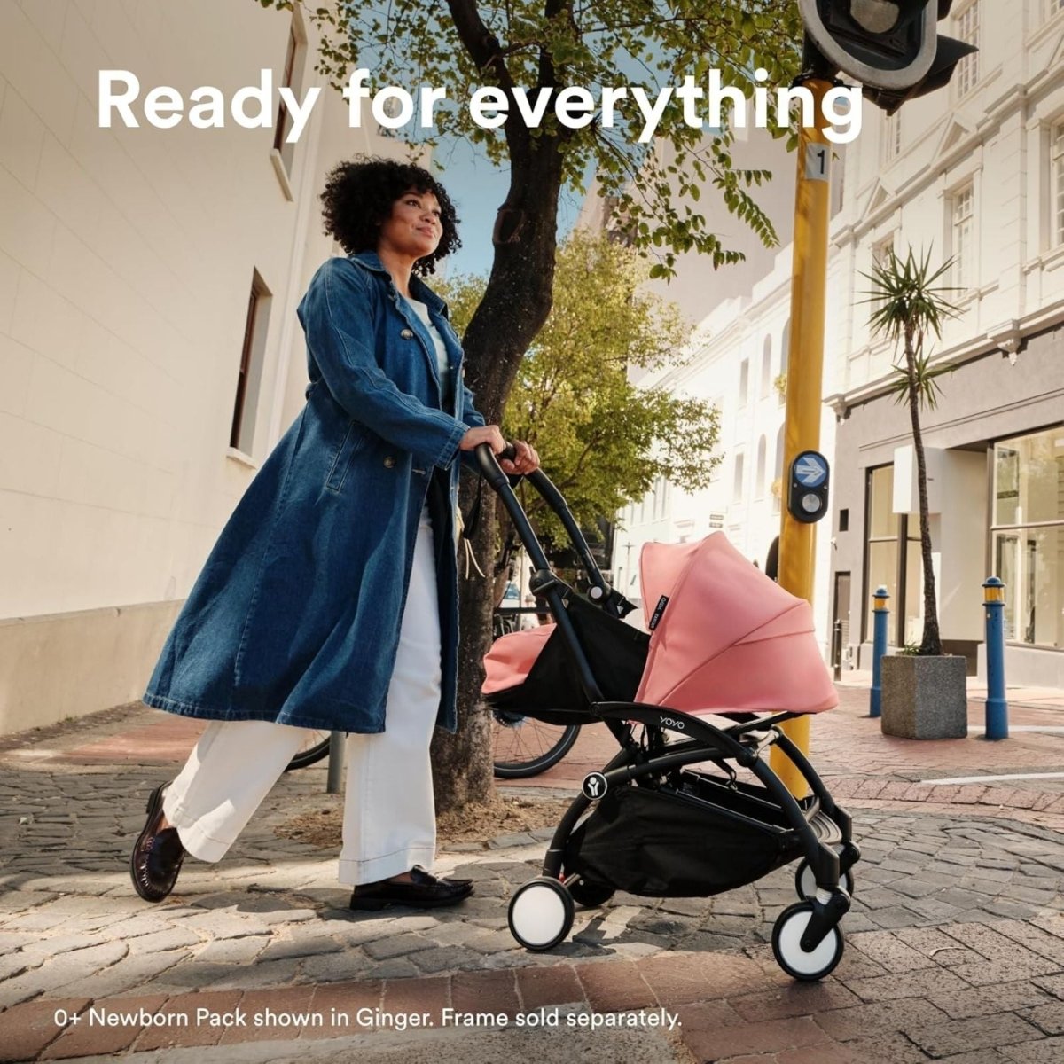 Black YOYO³ stroller with newborn carrycot, walking outdoors