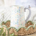 Ceramic flower jug with ditsy floral print, curved lavender handle, butterfly topper