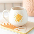 White rounded ceramic mug with gold sun illustration and 'Good morning, Sunshine' text