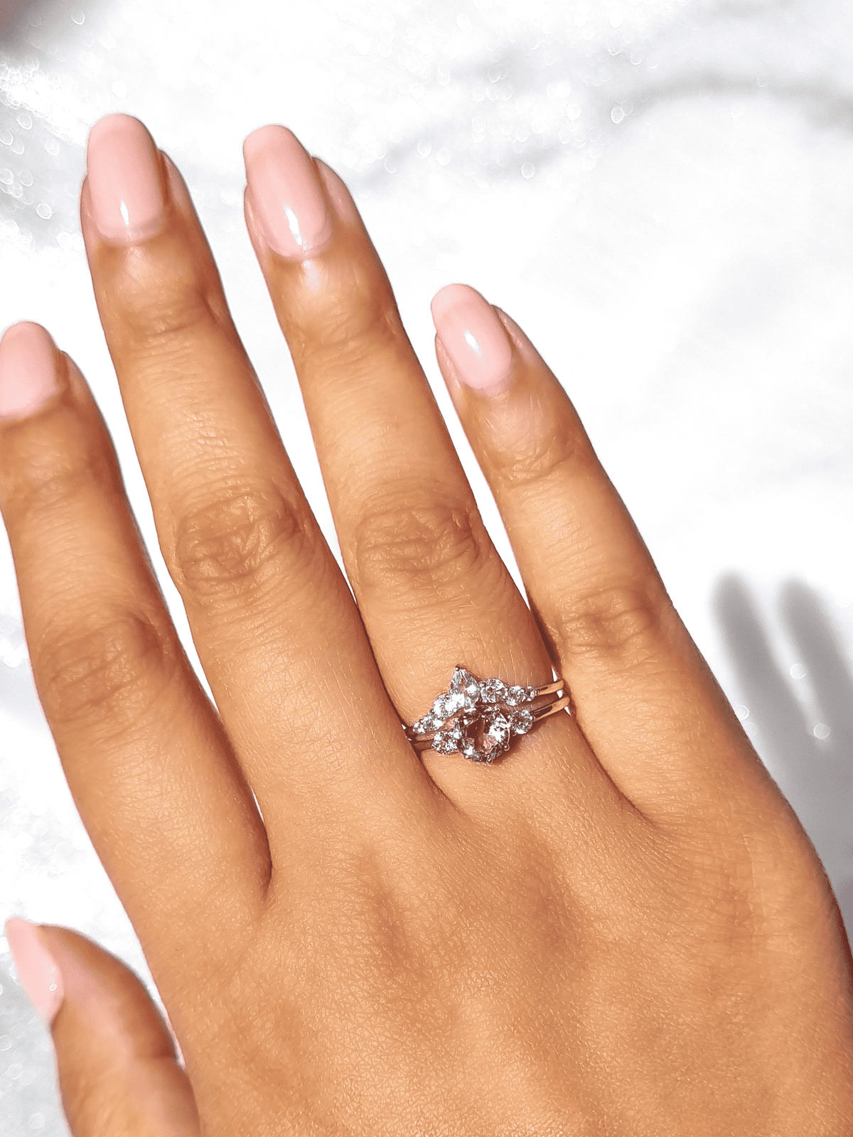 Lavender amethyst solitaire ring with clear stone detailing on an open hand