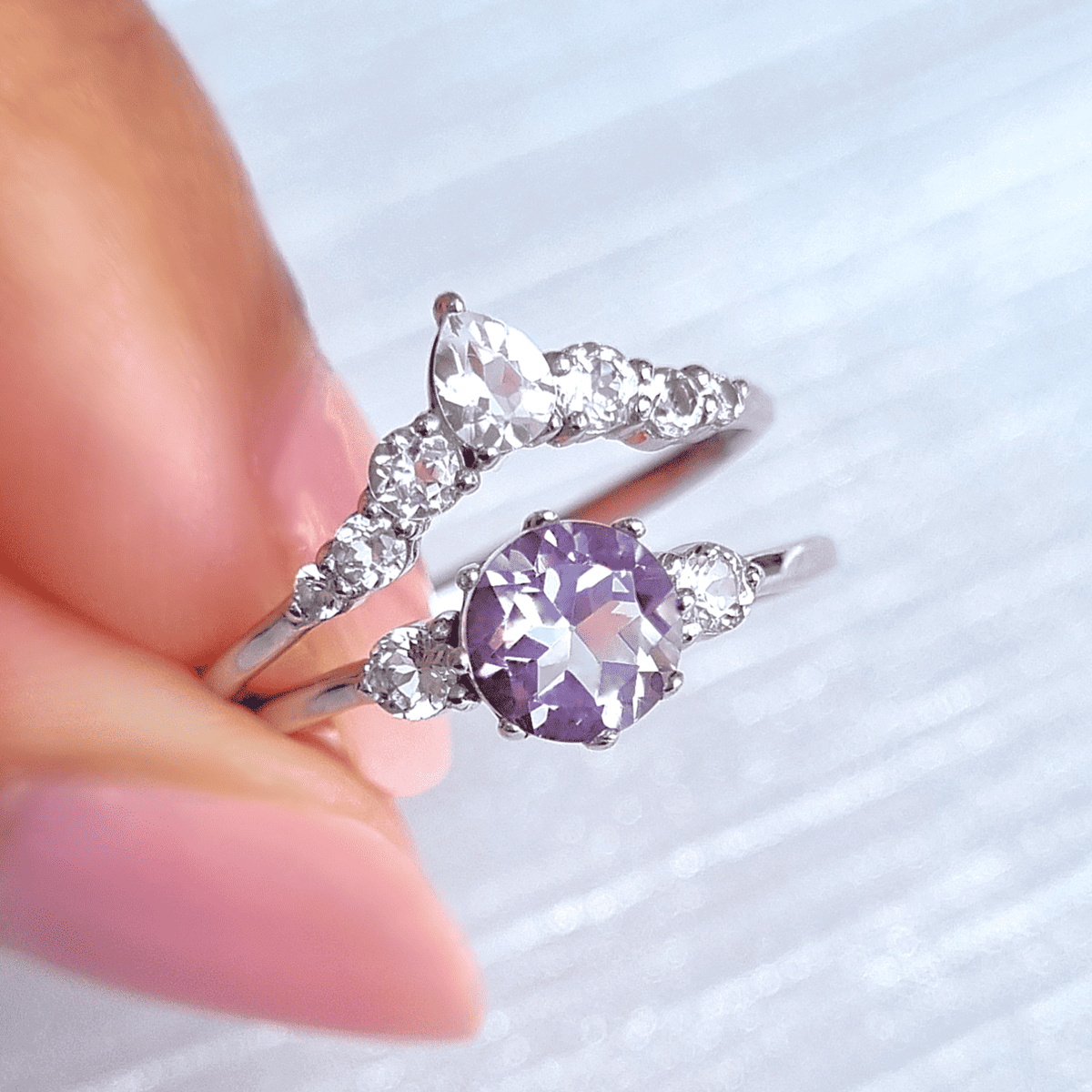Sterling silver ring set with round lavender amethyst and sparking side stones
