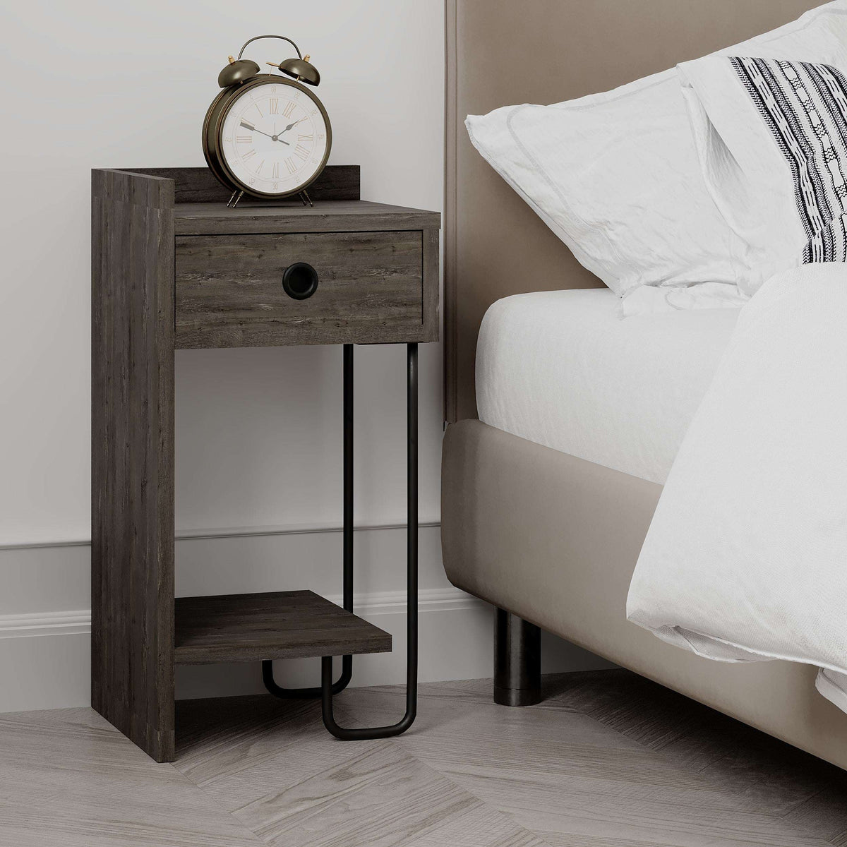 Dark wood bedside table next to bed, featuring a front drawer, open shelf, and black legs