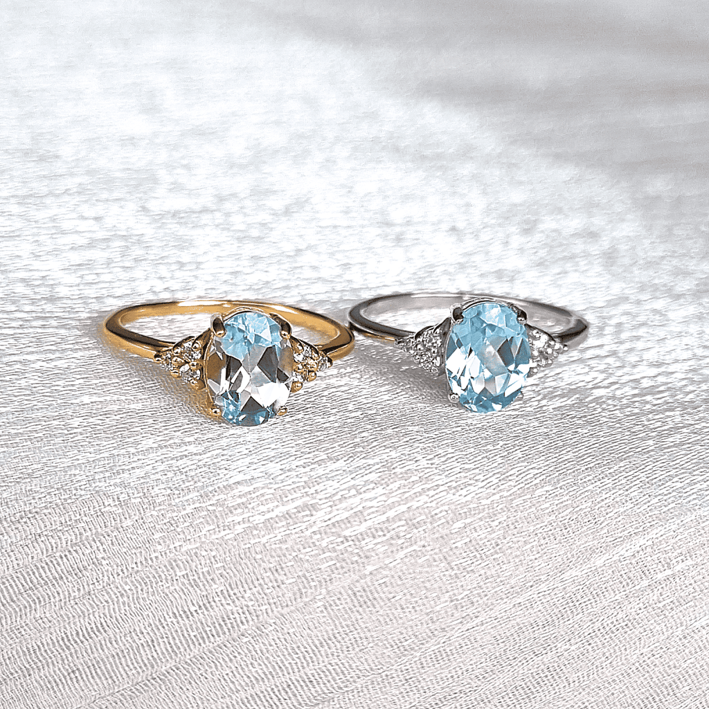 Gold vermeil and silver-tone rings with oval sky blue topaz and three side stones