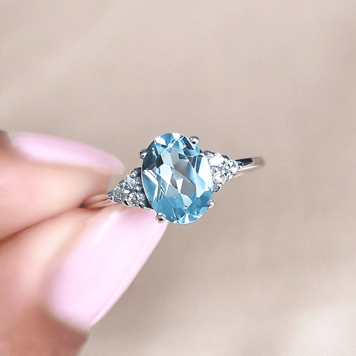 Sky blue topaz oval ring in sterling silver with diamond halo side stones