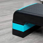 Close-up of aerobic step corner: black deck with blue edge and textured surface