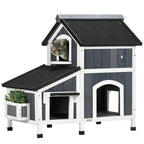 Grey wooden cat house with flower pot, arched doorways, windows, two levels