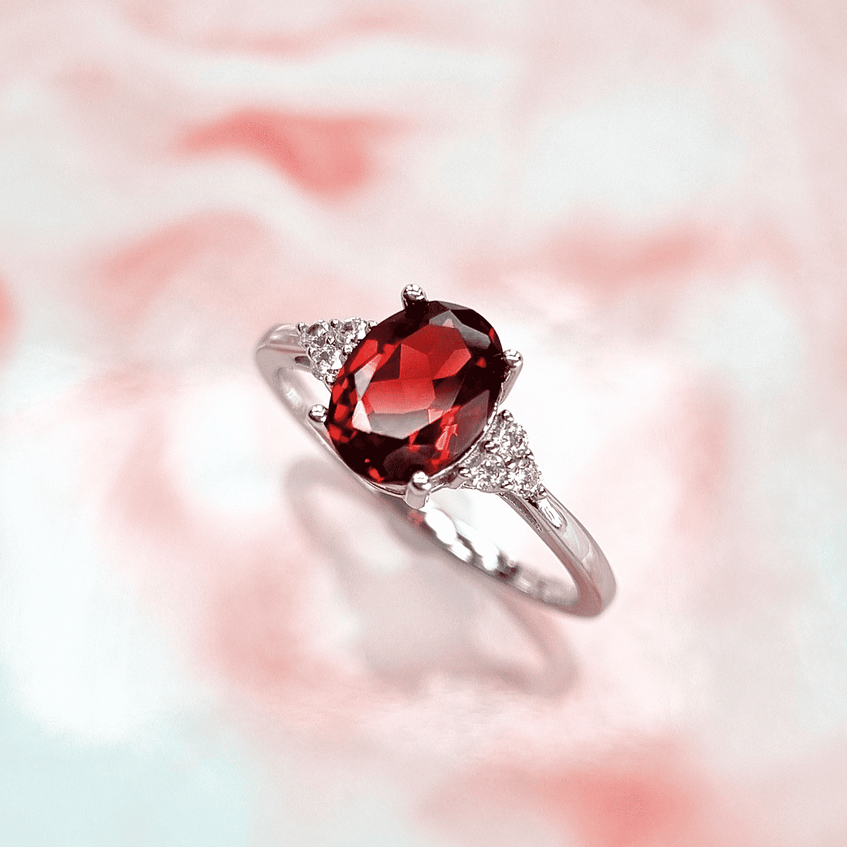 Sterling silver garnet ring with oval red gemstone and side stones