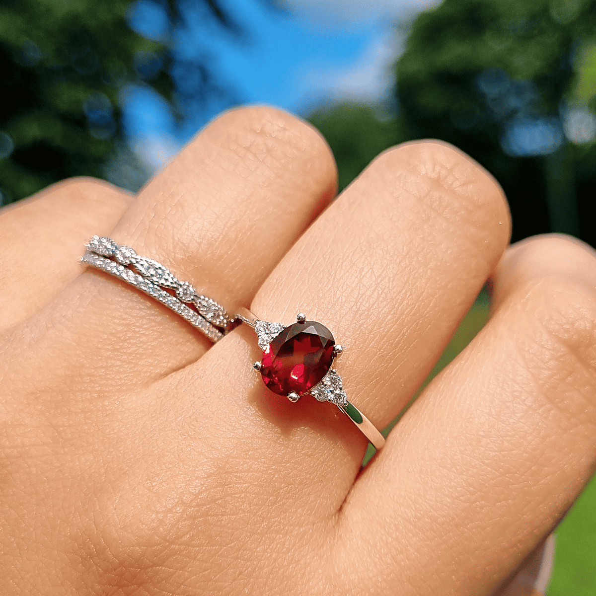Sterling silver garnet ring with oval red stone and split pavé band