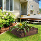 Brown wooden raised planter in backyard with soil and green plants, open top.