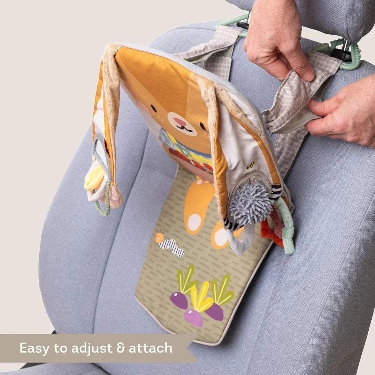 Adjustable hanging bunny activity toy attached to a car seat with textured grip loops