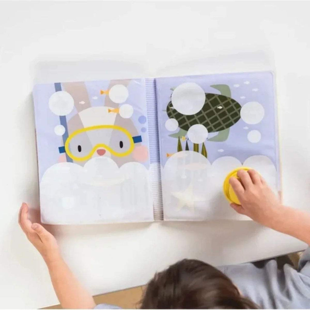 Open water book showing bunny goggles scene; yellow stamp held near page