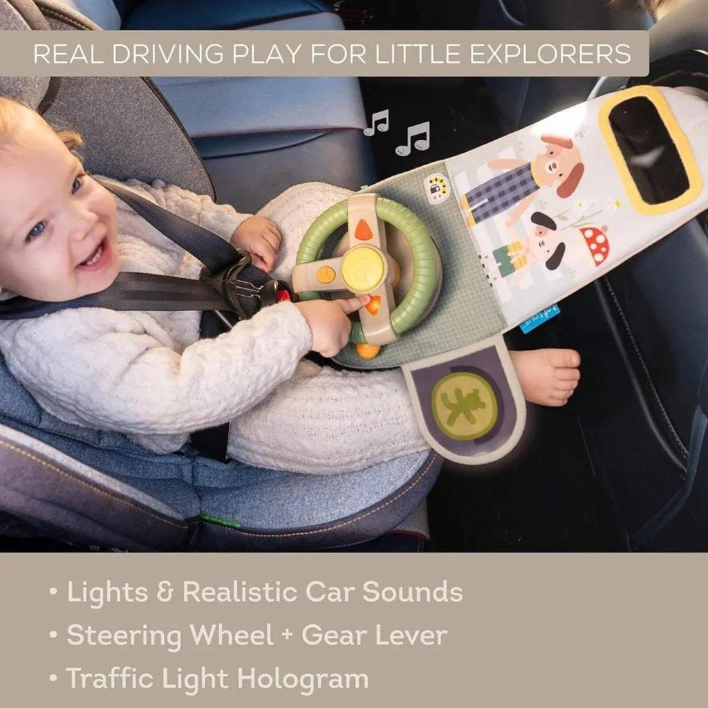 Baby playing with travel toy dashboard featuring green steering wheel and sound gear