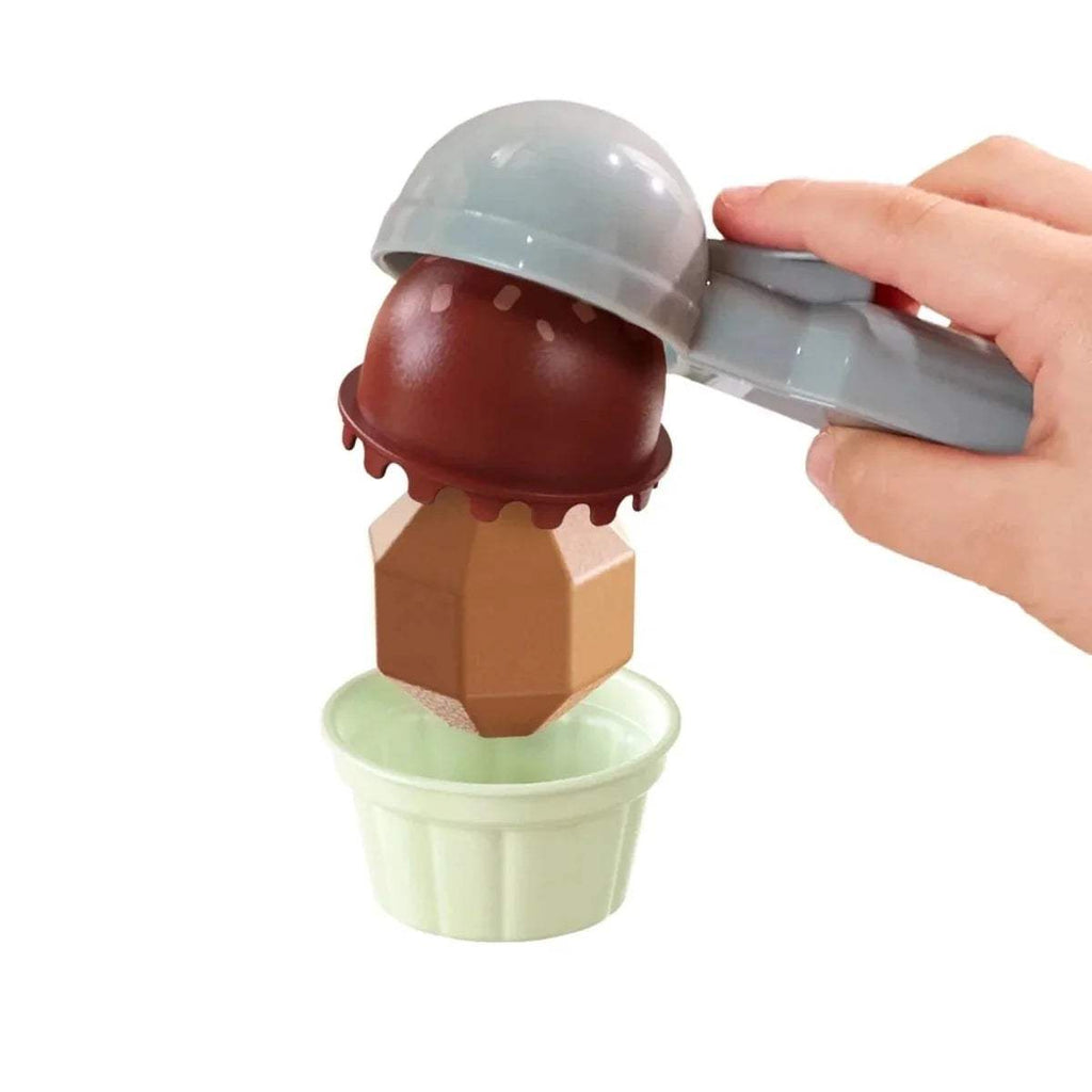 Dark chocolate scoop filling a pale green cup with a teal dispenser head