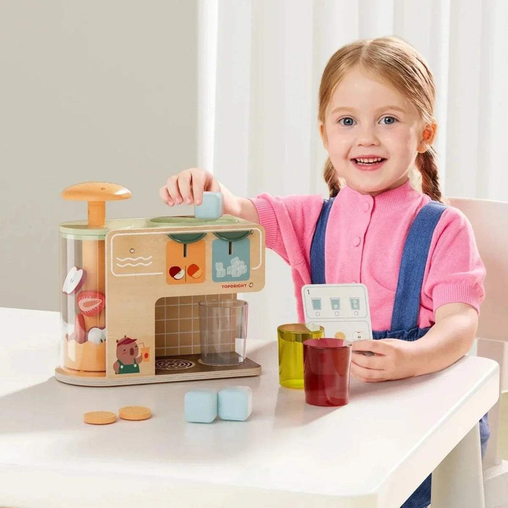 Wooden juice kiosk play set with cups and pale ice cubes on a table