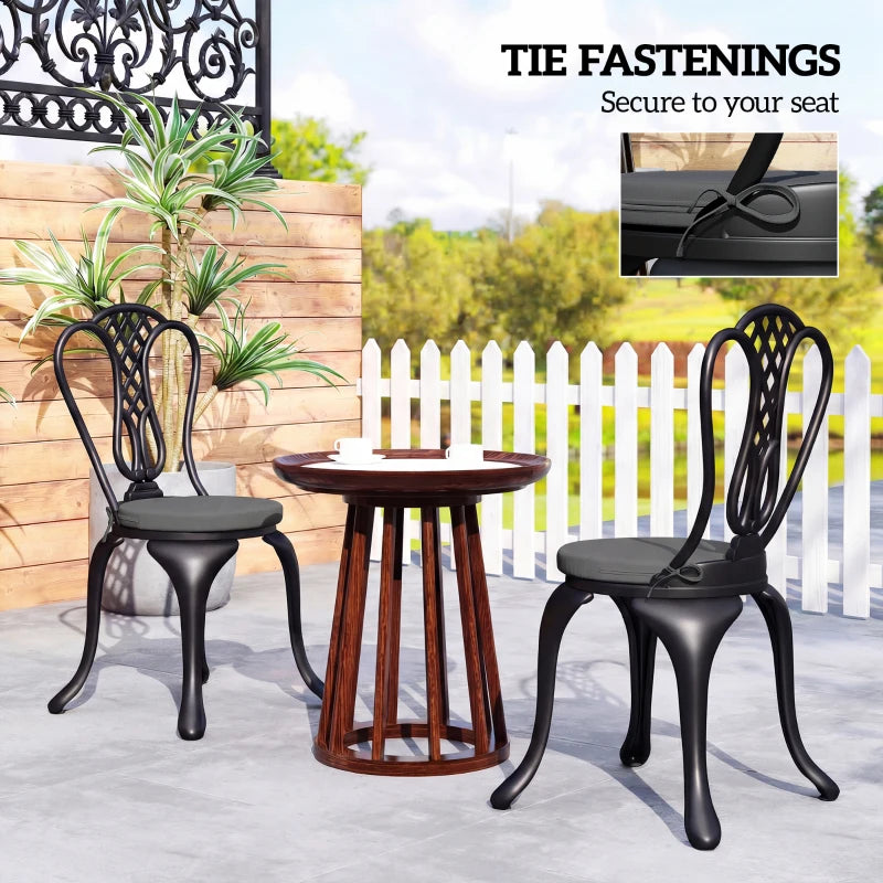 Four dark grey round seat cushions with ties on outdoor dining chairs