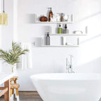 White U-shaped floating wall shelves mounted near a sink with open storage compartments