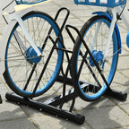 Black floor bike rack holding two bicycles with upright wheel supports and rubber feet