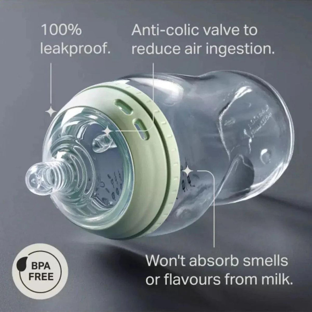 Glass baby feeding bottle with mint anti-colic valve and silicone nipple, close-up