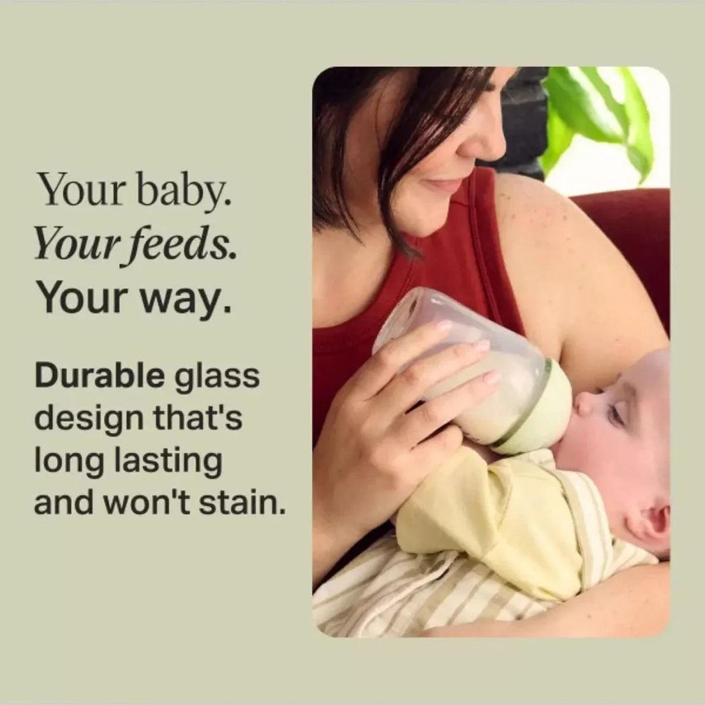 Durable glass baby feeding bottle with mint cap, shown during feeding