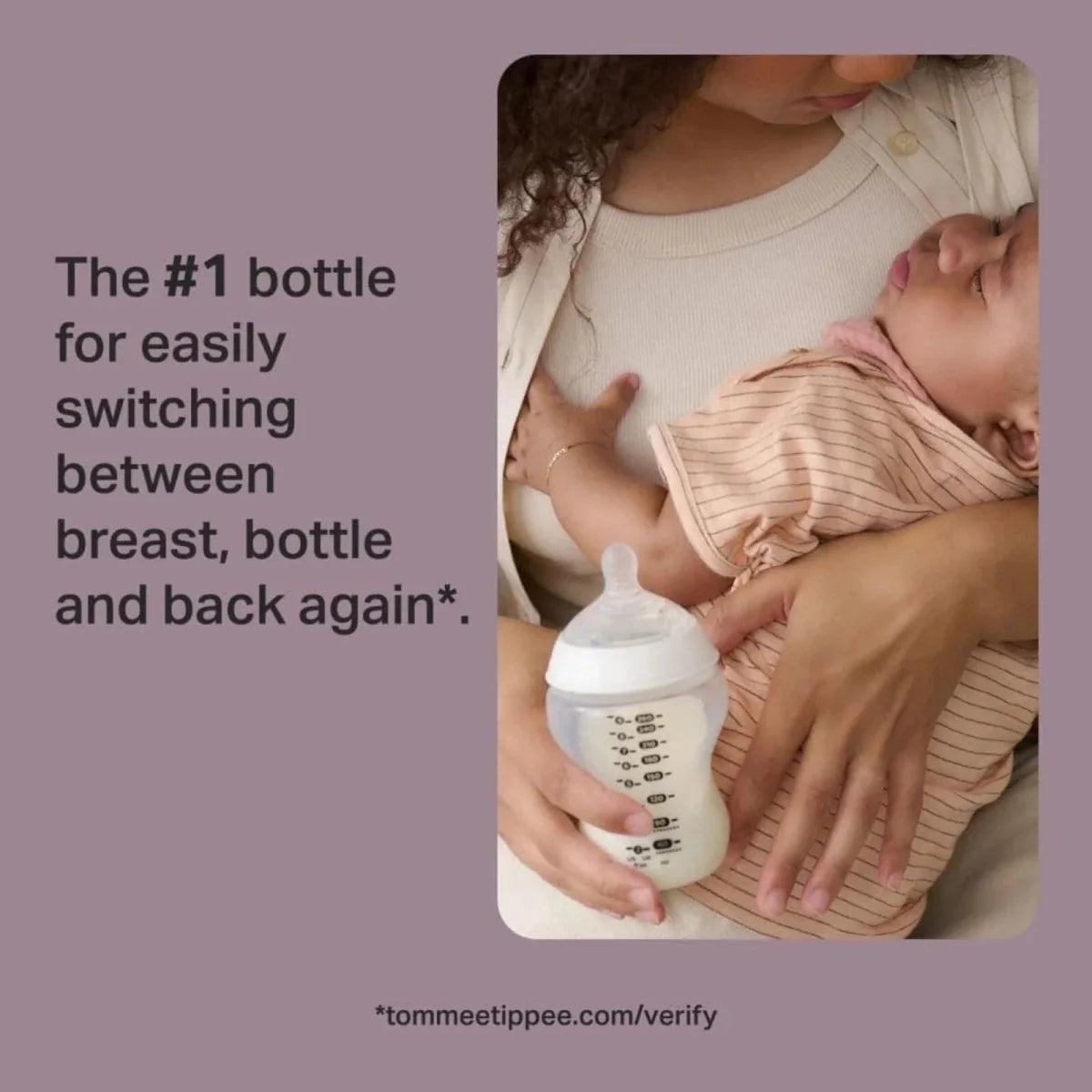 Parent feeding a newborn with a clear baby bottle while holding the baby close