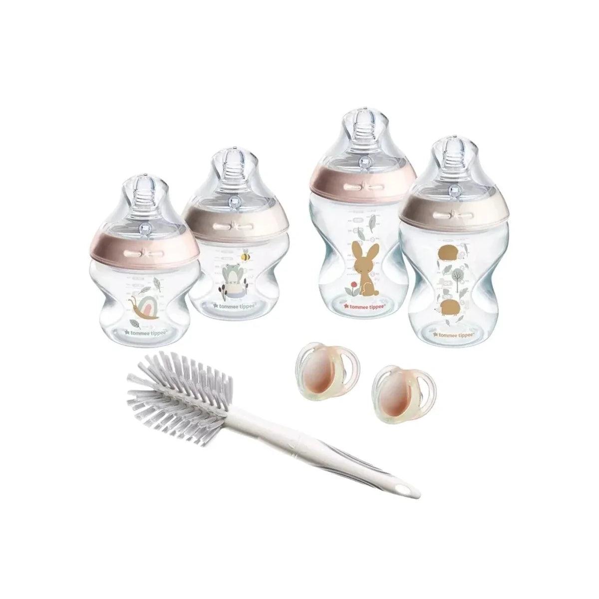 Pink newborn bottle starter kit set with bottles, cleaning brush, and spare caps