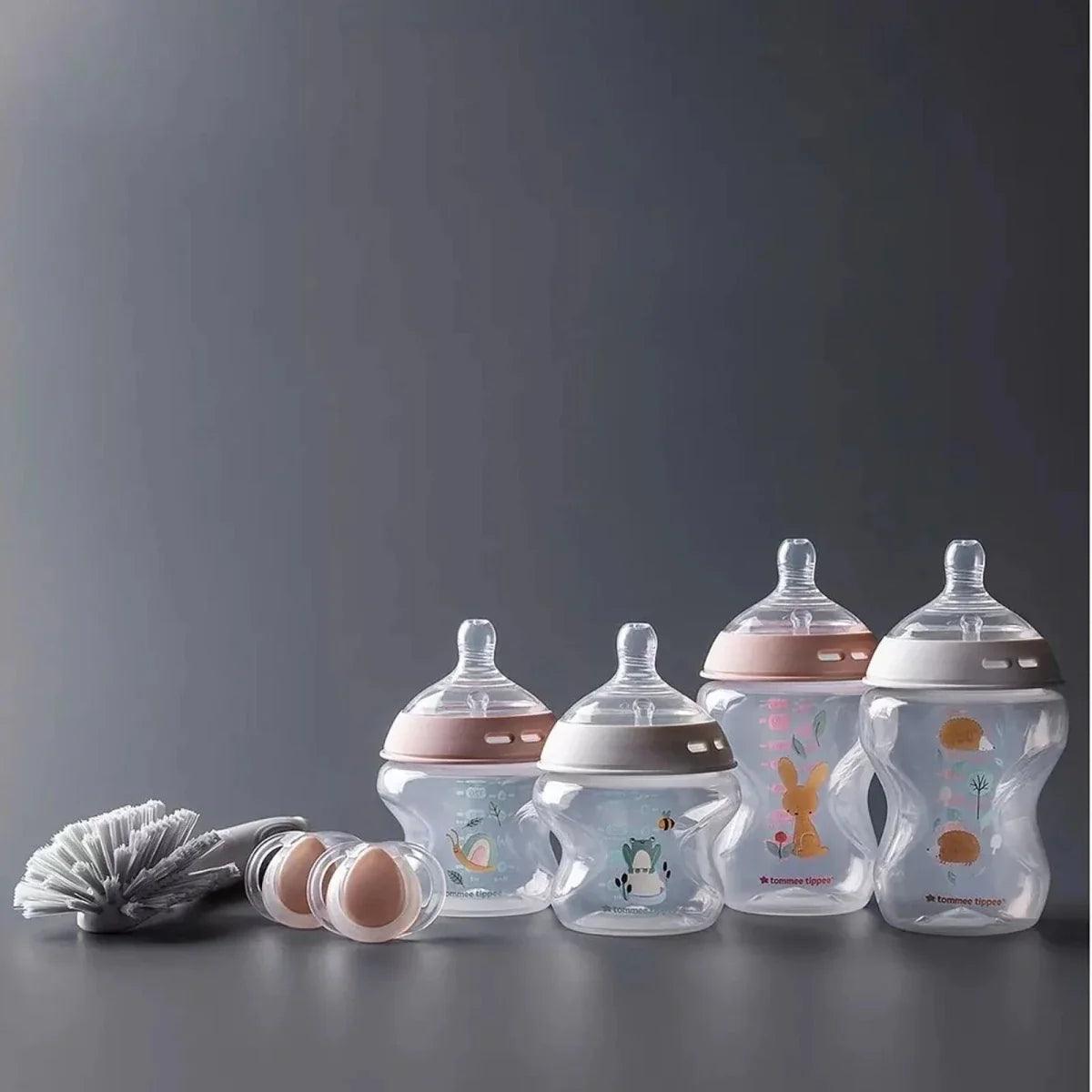Pink and clear newborn bottles set with caps and cleaning brush accessory