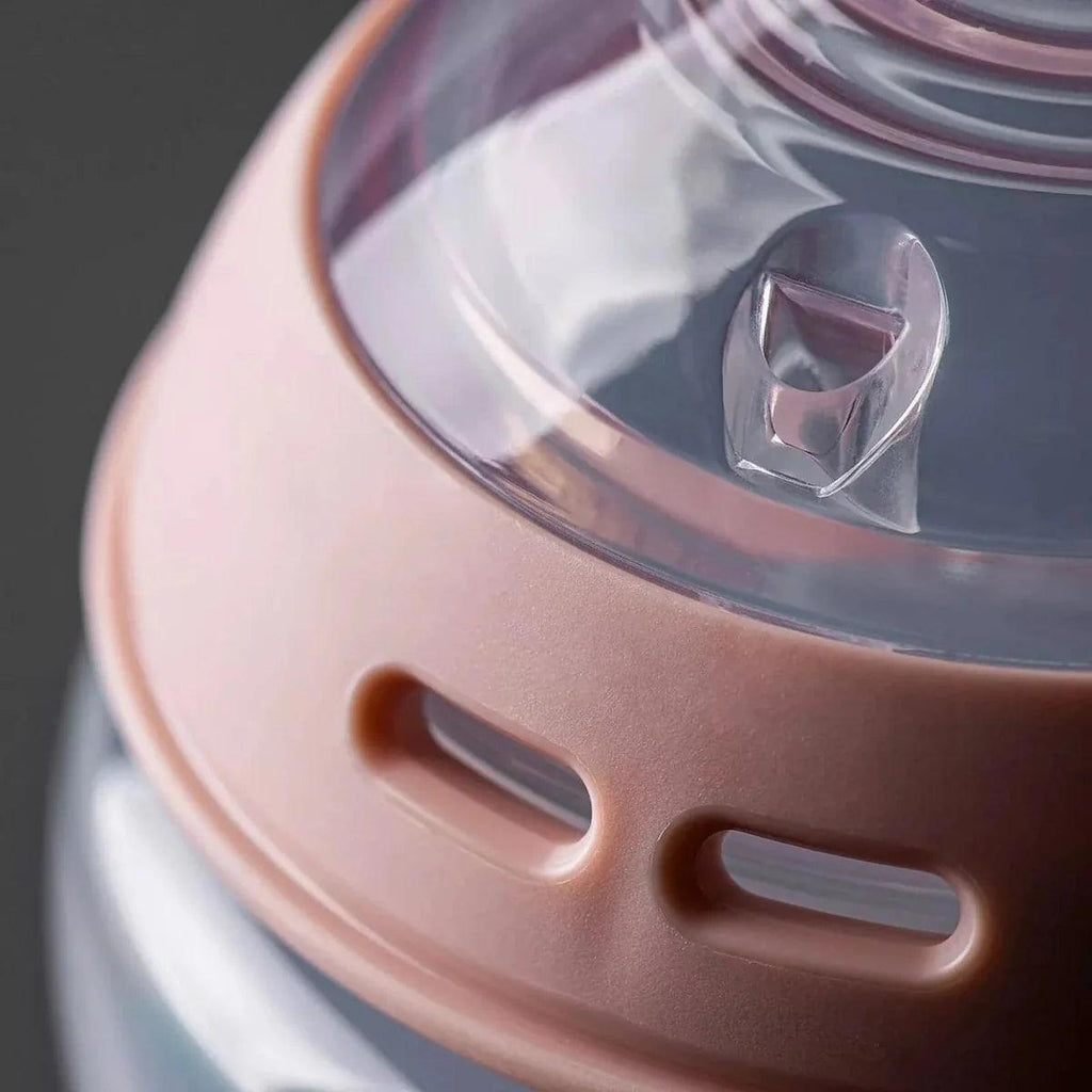 Pink baby bottle lid with vented steam cover detail