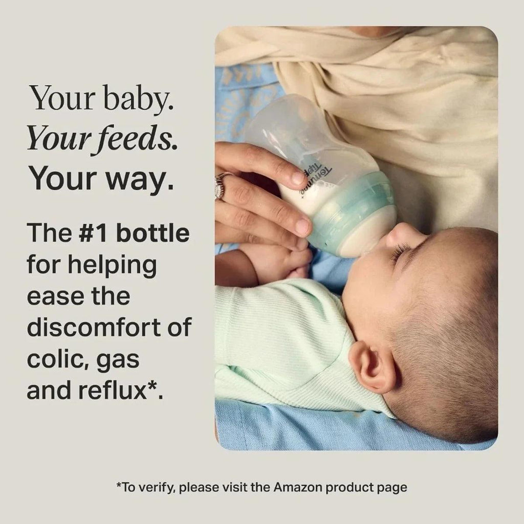 Baby being fed with a teal anti-colic bottle held by an adult