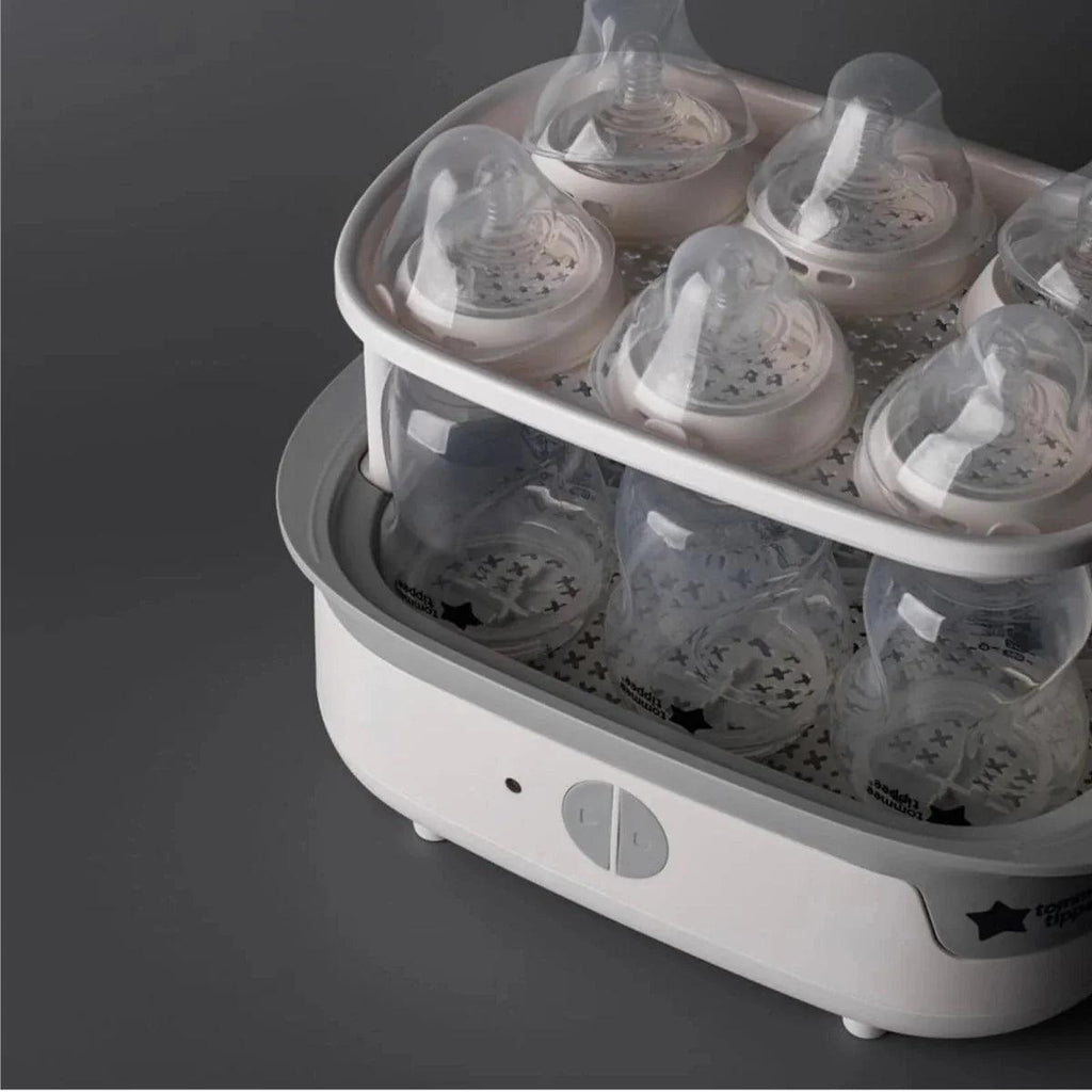 Opened steriliser tray with multiple baby bottles and teats arranged
