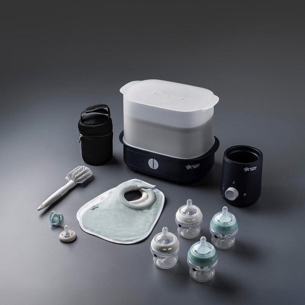 Black electric steam steriliser with bottle warmers, bottles, and grey cloth bib