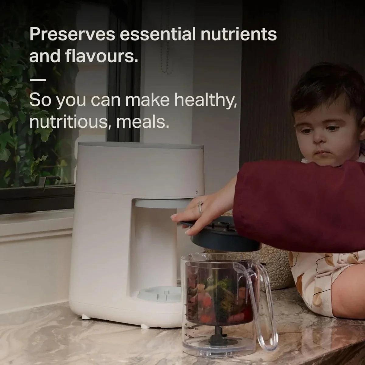 White baby food maker with clear jug and pitcher on kitchen counter