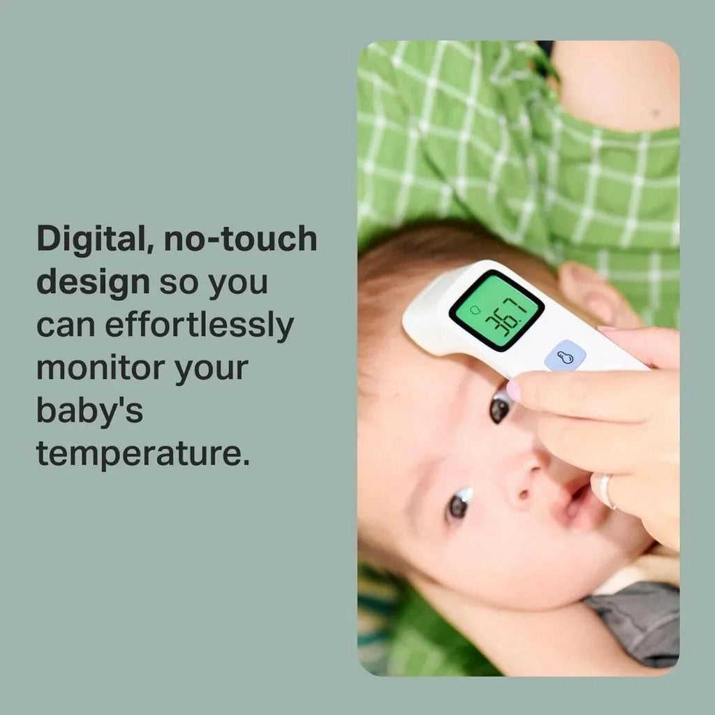 No-touch forehead thermometer held near a baby's forehead with green LCD