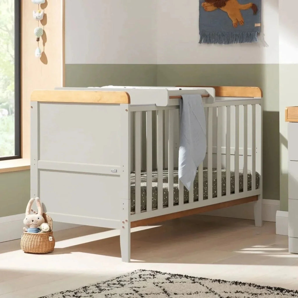 Dove grey cot bed with raised end panels and light wood mattress rails