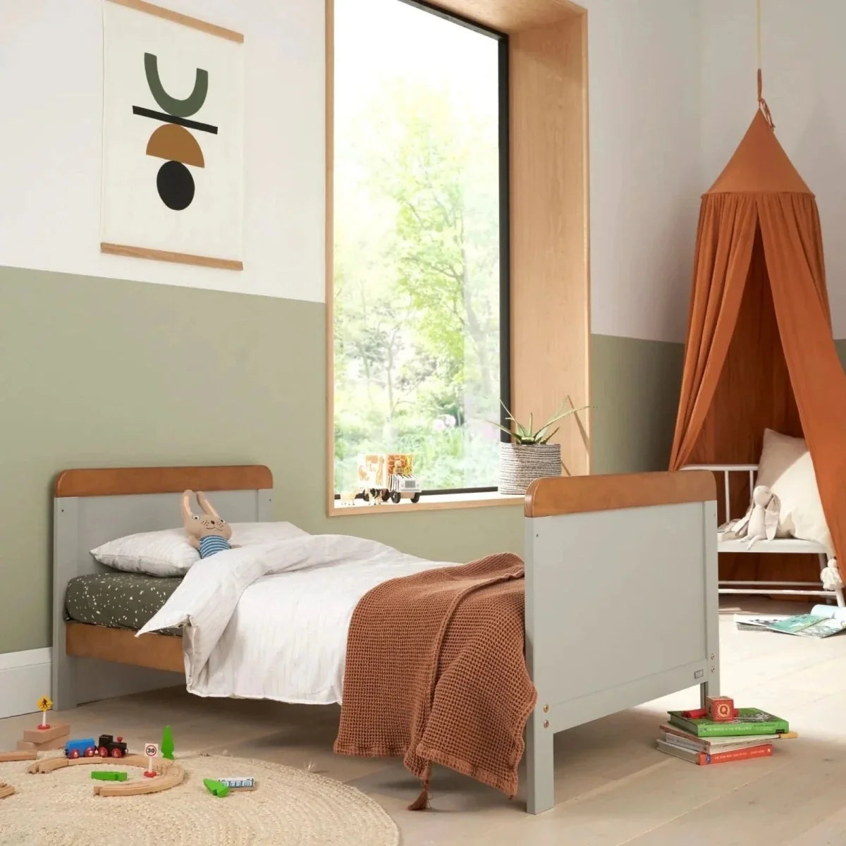 White junior bed with light wood top rail and toddler blanket on bedding