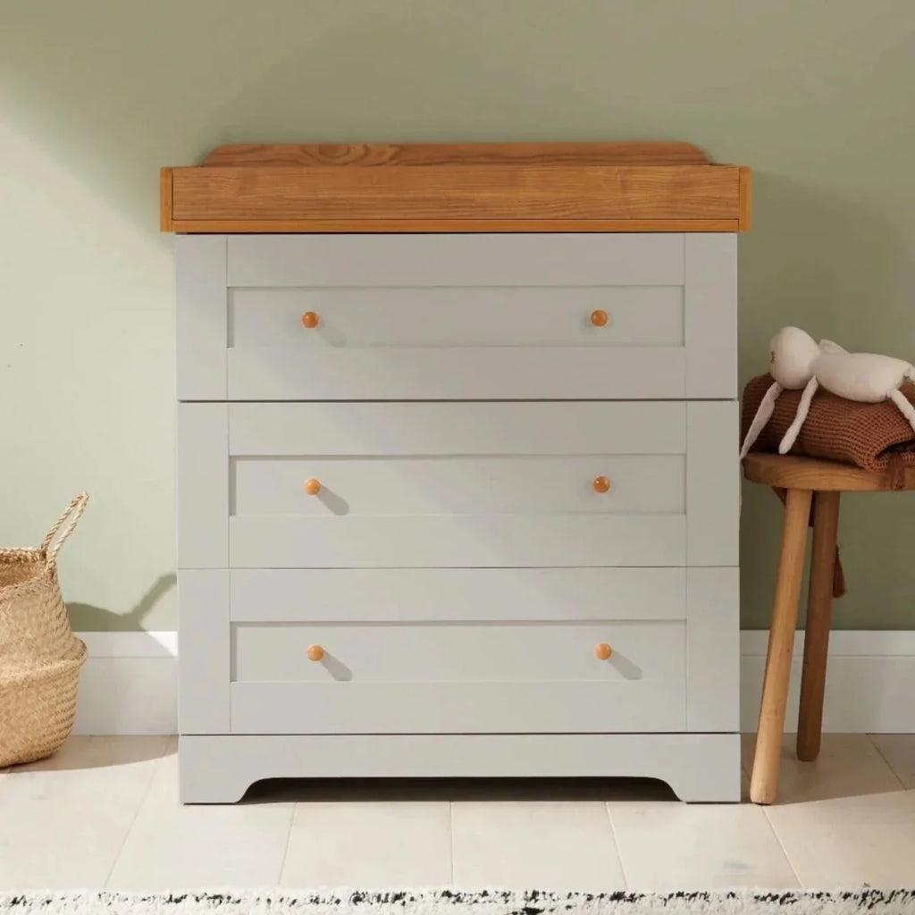 Light wood and white dresser with multiple drawers and round wooden knobs
