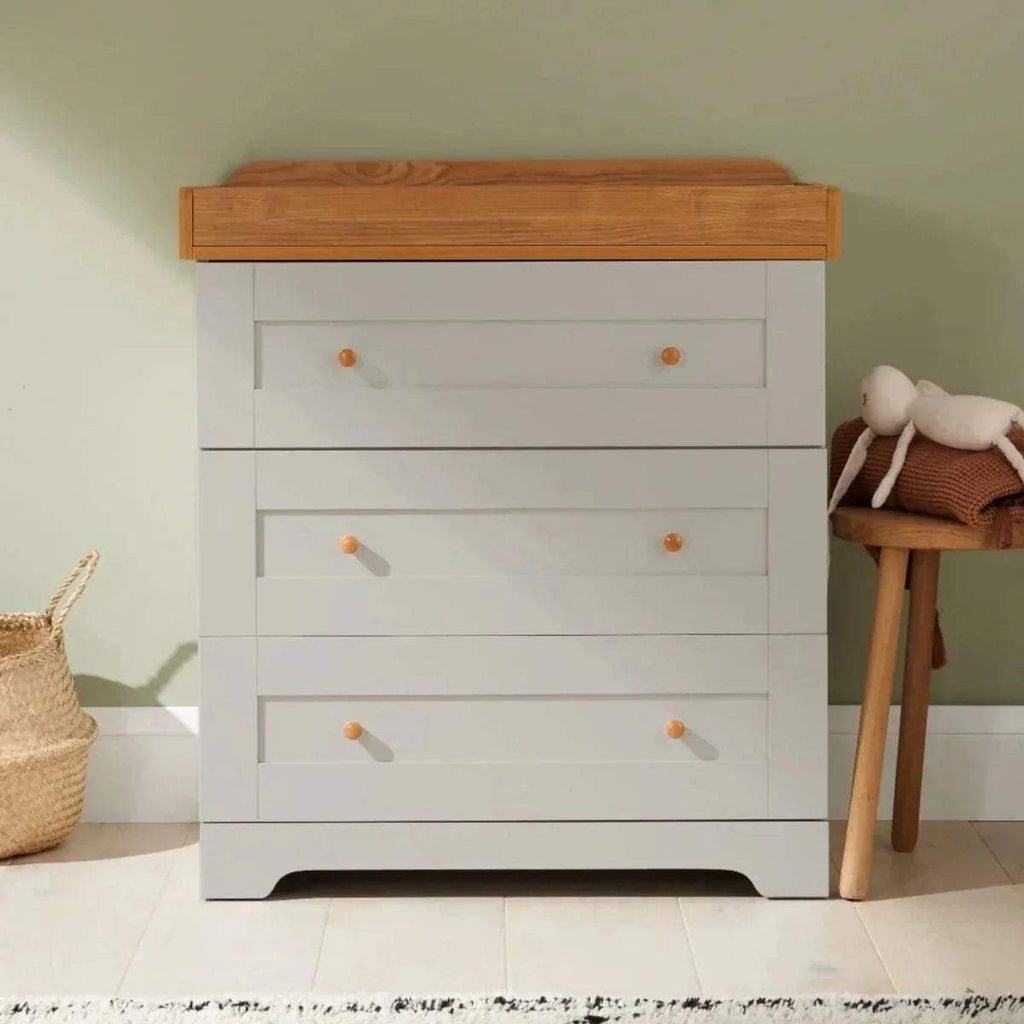 Dove grey nursery dresser with honey oak top and gold knob drawer pulls