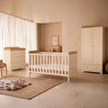 Wooden baby crib with guard rails, plus matching dresser and wardrobe in light honey oak
