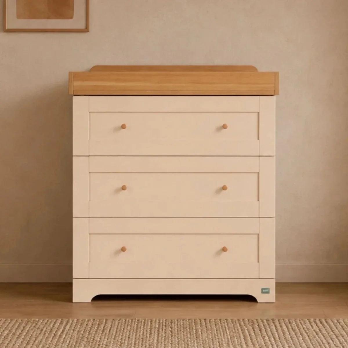 White baby dresser with honey oak top, three drawers, round knobs and tapered legs