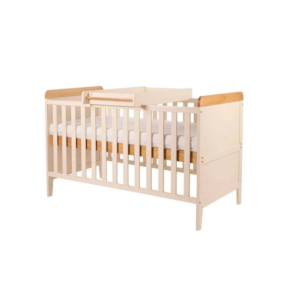 White crib with honey oak rails and corner posts, side view with guard panel detail