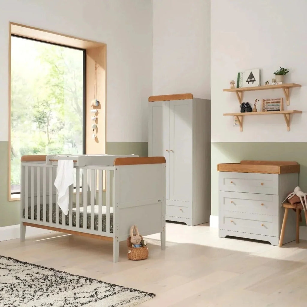 Dove grey and white cot bed with slatted sides and honey oak rail accents