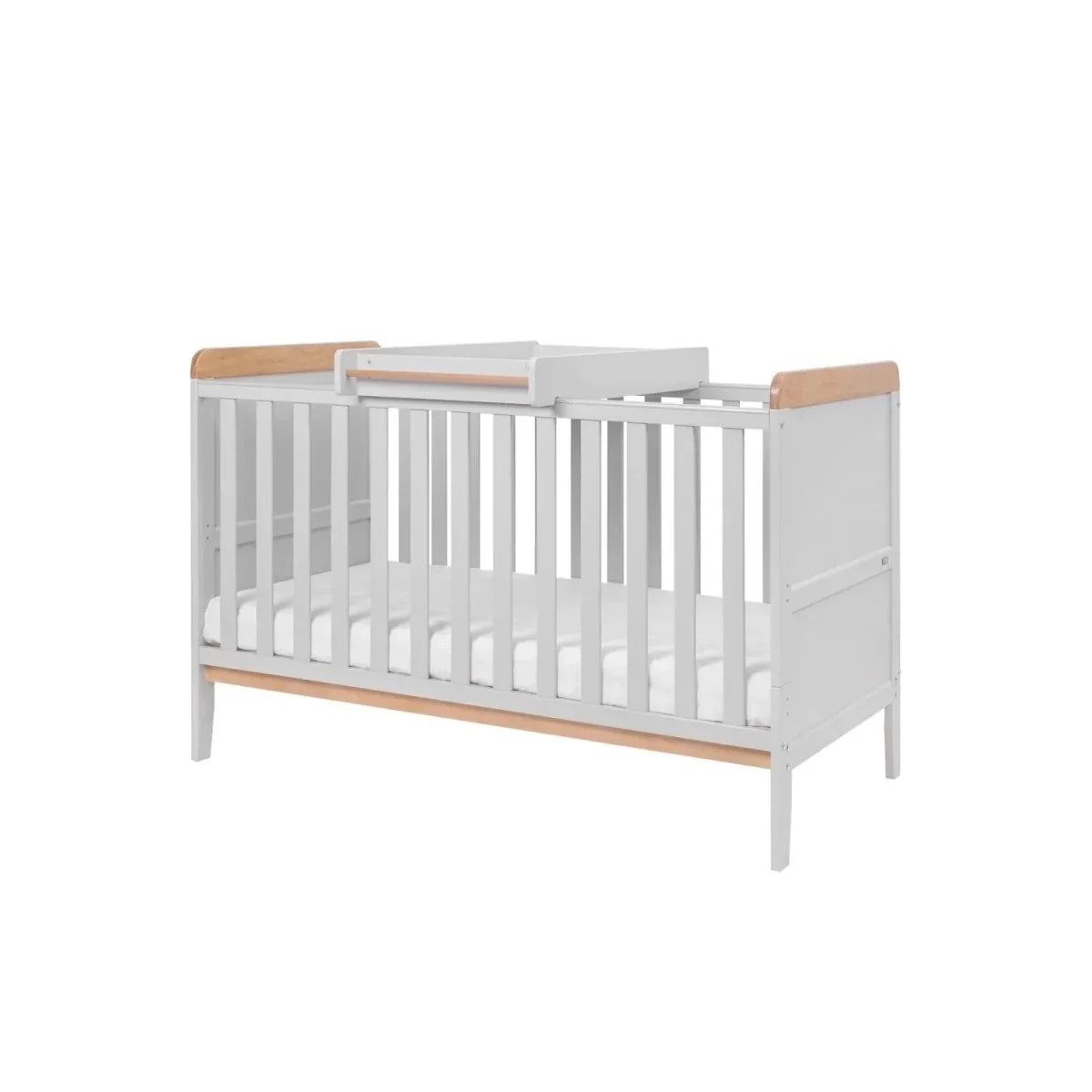 White cot bed with slatted sides and honey oak rails, elevated mattress base view