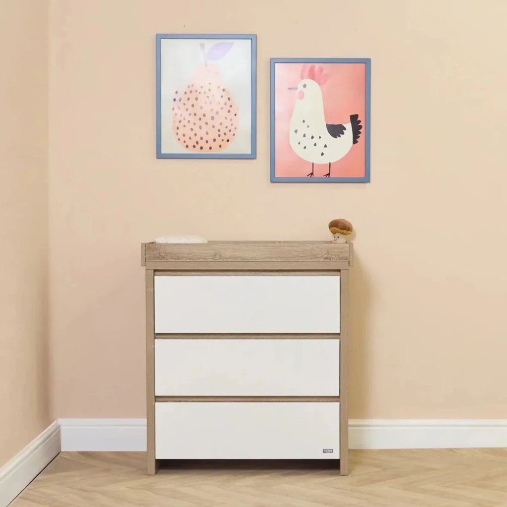 White and light oak baby dresser with three drawers and top ledge