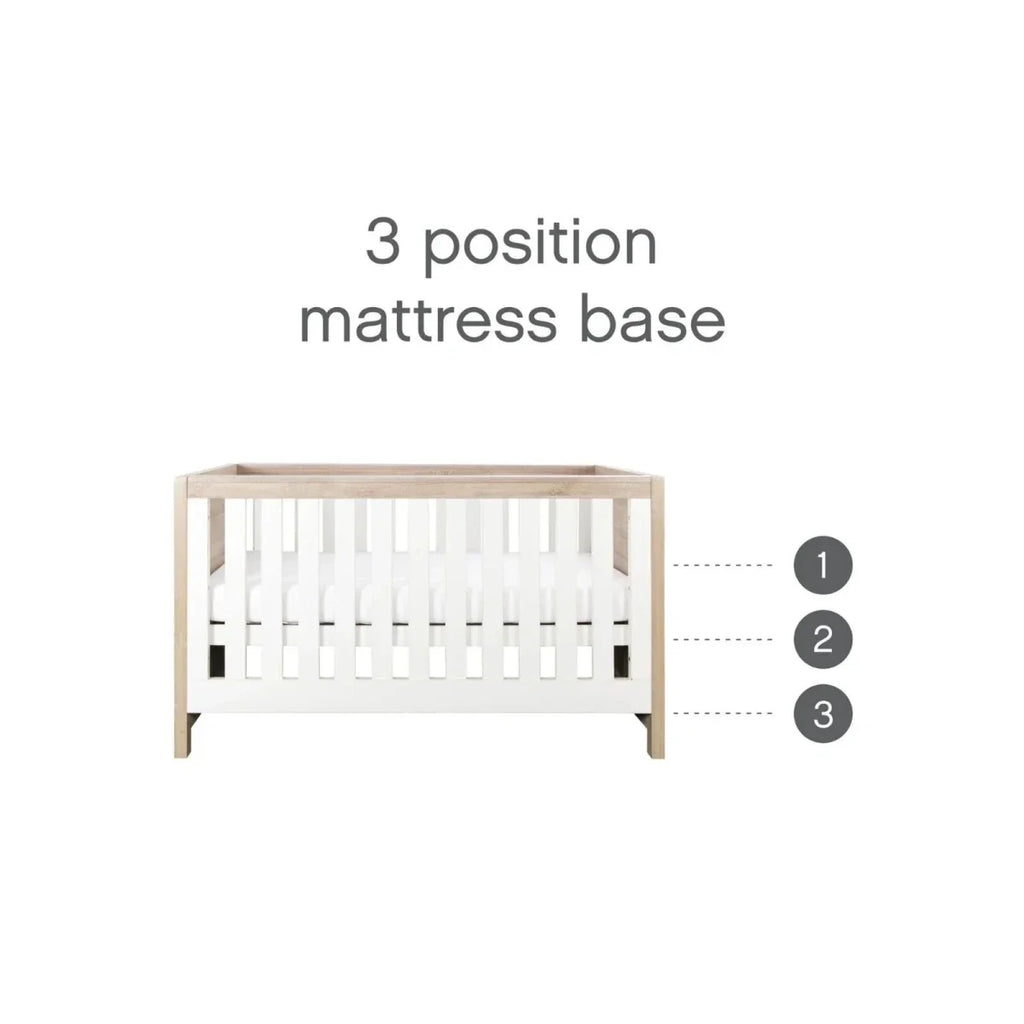 Cot bed mattress base showing three height positions within white slat frame