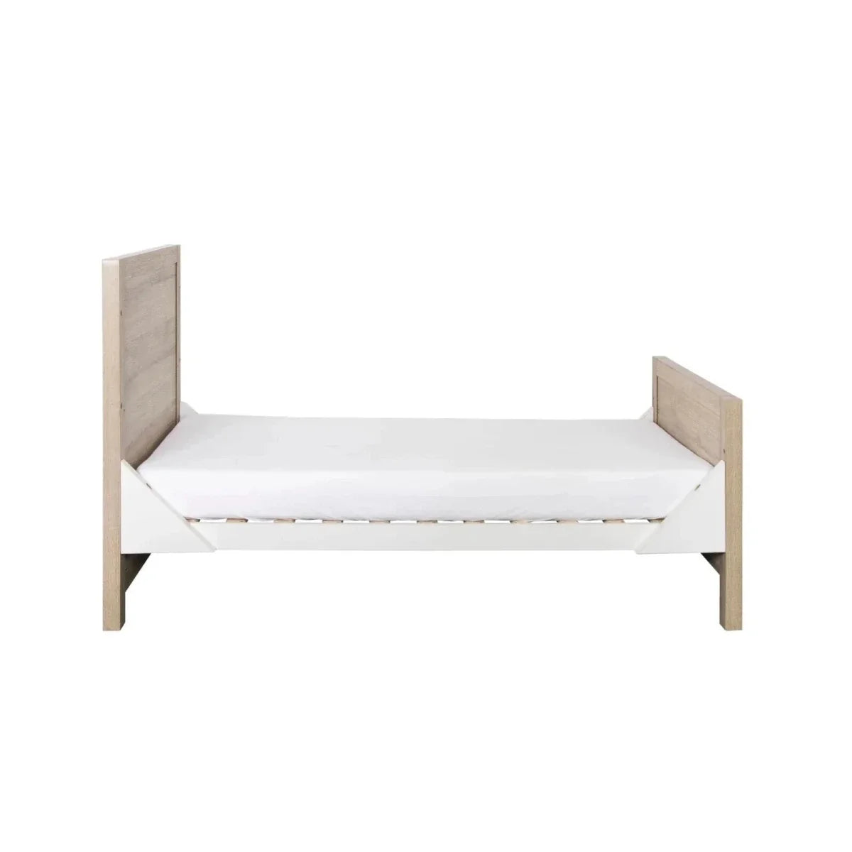Children’s wooden cot bed with white mattress and side panels, light oak finish