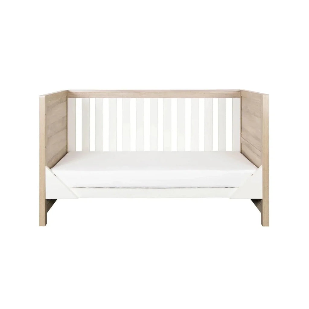 Children’s cot bed with white slatted headboard and matching light oak sides