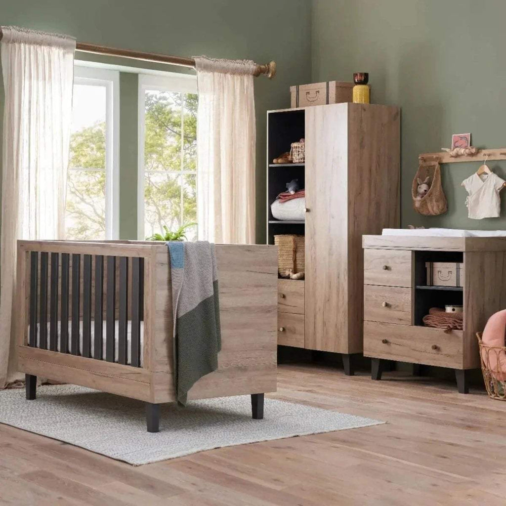 Baby cot bed with distressed oak frame and dark vertical slats